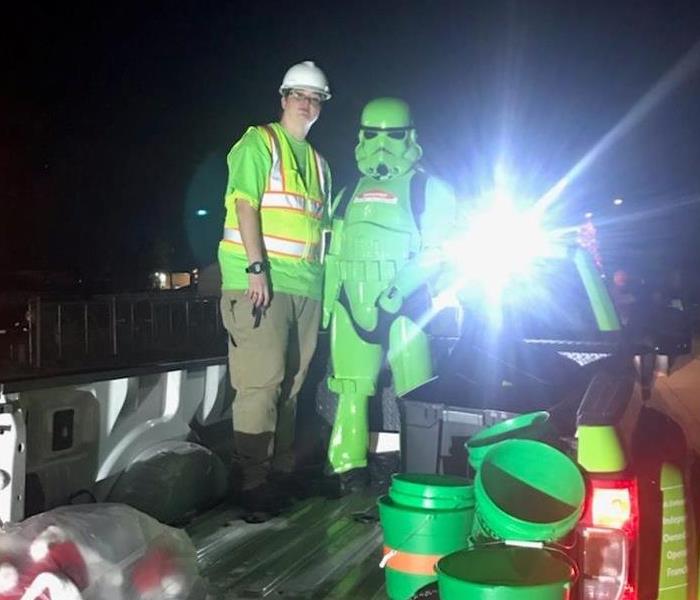 Technician dressed in safety gear next to a green storm trooper