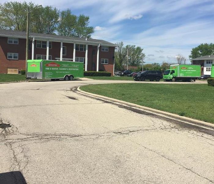 SERVPRO trucks outside of brown apartment building