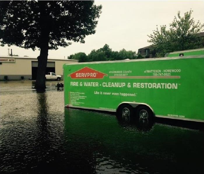 SERVPRO truck in flooded street next to a tree