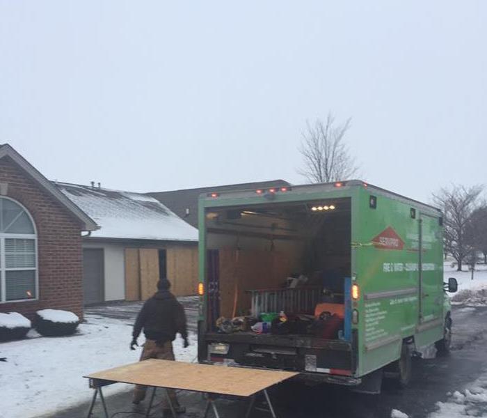 SERVPRO truck and one worker outside of home in snowy weather
