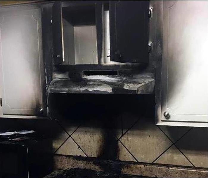 White cabinets above stove damaged by fire