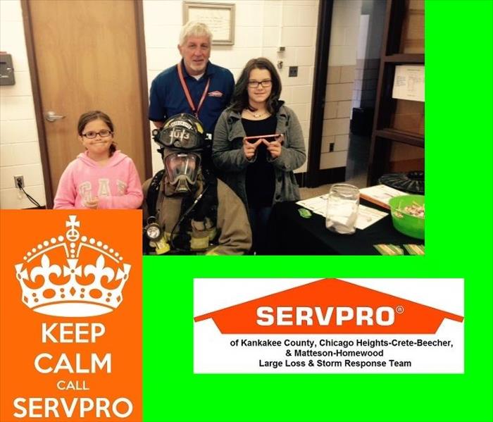 Male SERVPRO rep with two girls and a fire fighter